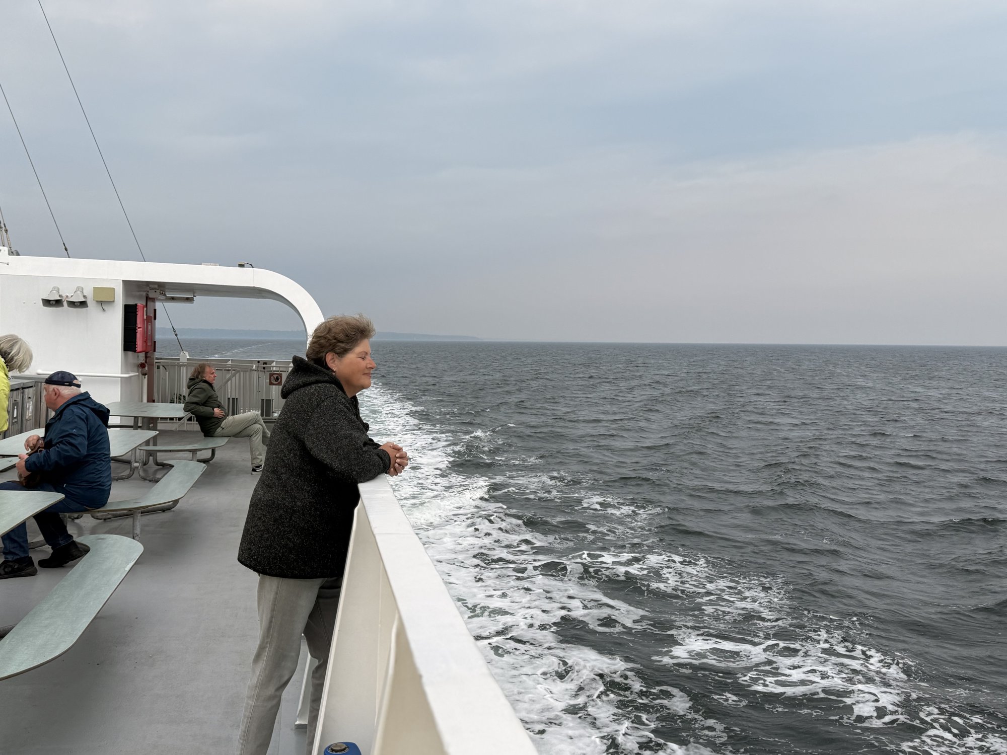 Tanja an der Reling der Fähre, graue See mit weißem Kielwasser