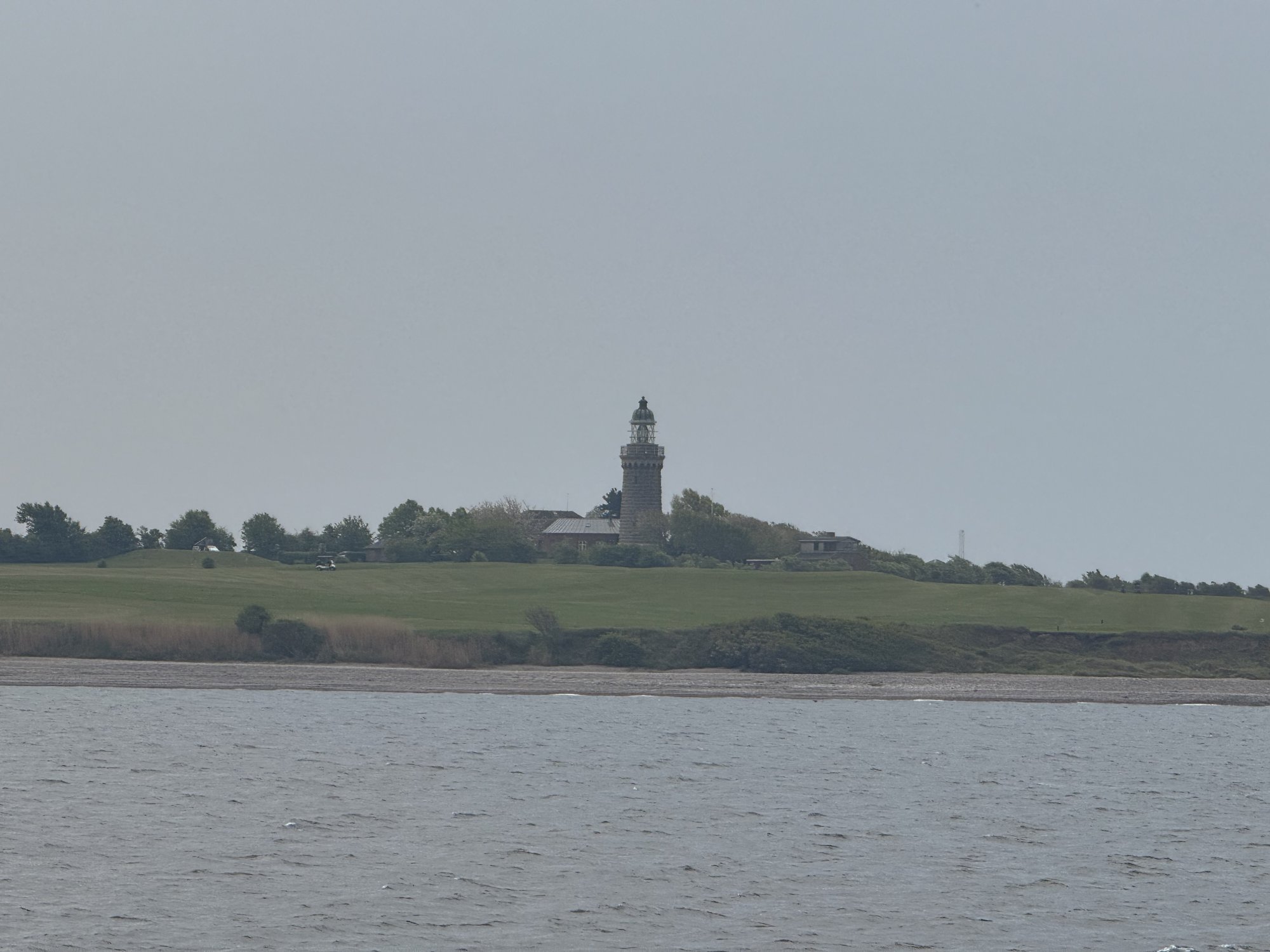 Der Leuchtturm Skjoldnæs Fyr über dem Golfplatz, vom Schiff aus gesehen
