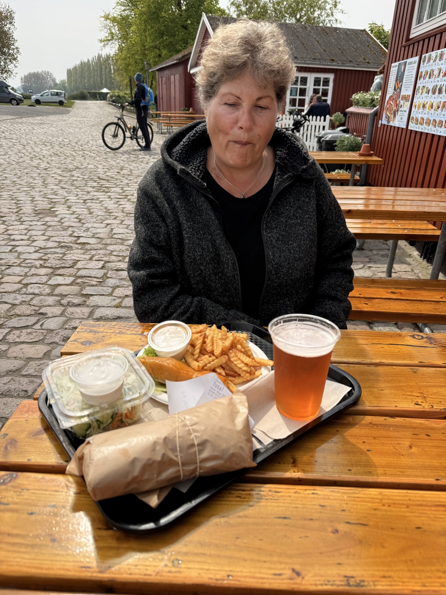 Tablett mit Fisch, Pommes und Bier vor der Räucherei am Hafen