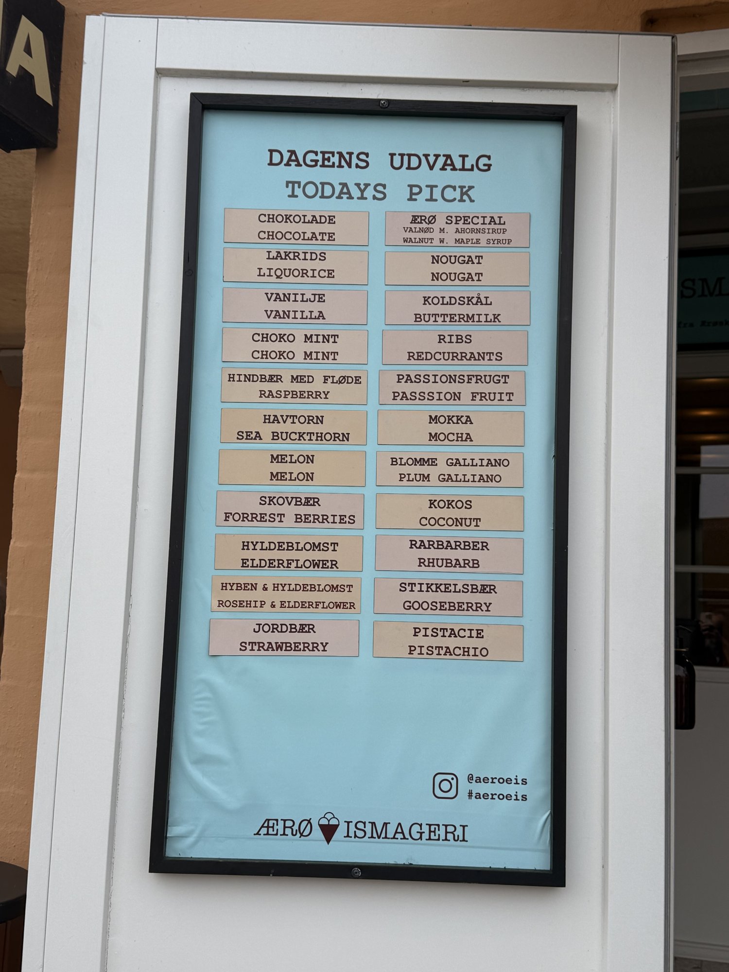 Tafel mit den 22 Eissorten des Ærø Ismageri, dänisch und englisch