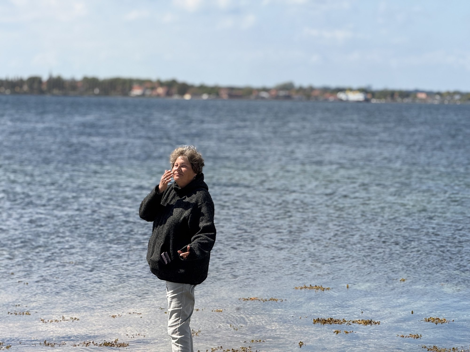 Tanja am Wasser mit einem Becher in der Hand