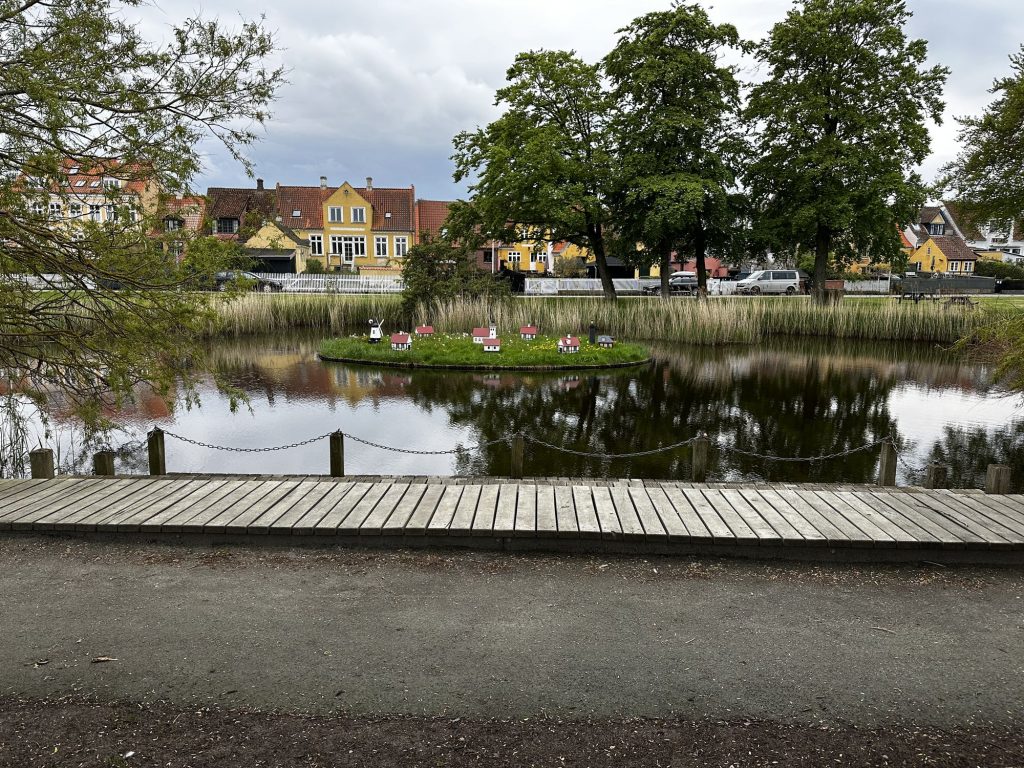 Kleine Insel im Teich von Ærøskøbing mit winzigen weißen Häuschen, Mühle und Leuchtturm