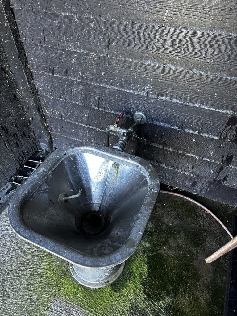 Die Toilettenentsorgung in Marstal: ein altes verzinktes Waschbecken auf einem Holzdeck