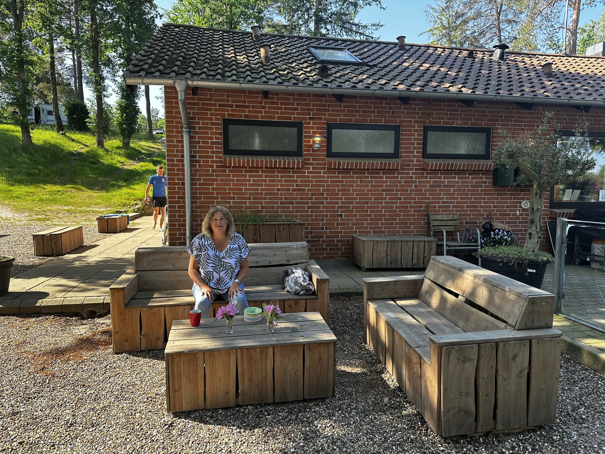 Tanja auf den Holzsofas vor dem Café des Campingplatzes