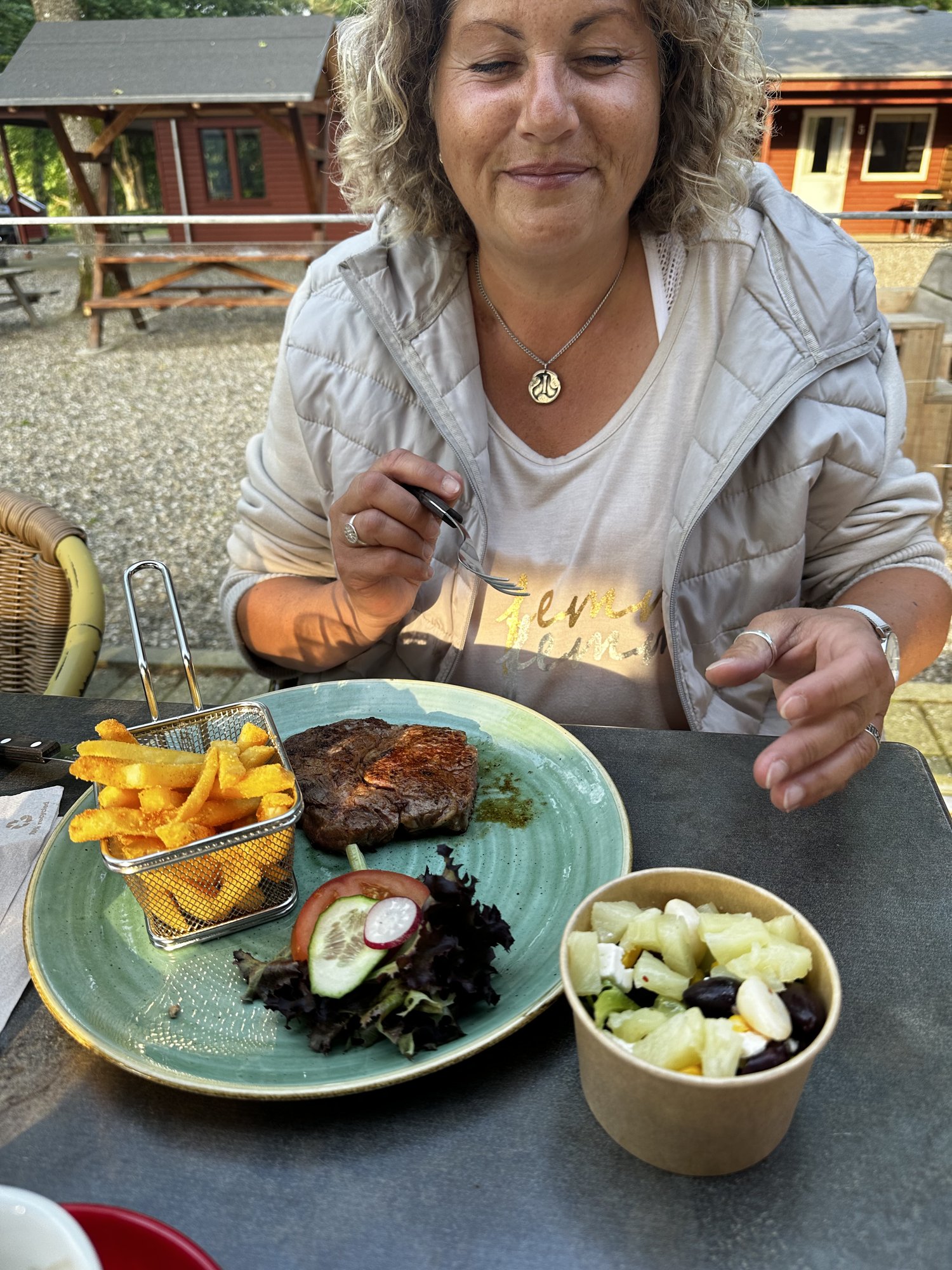 Tanja mit Ribeye-Steak, Pommes und Salat beim Freitagsmenü