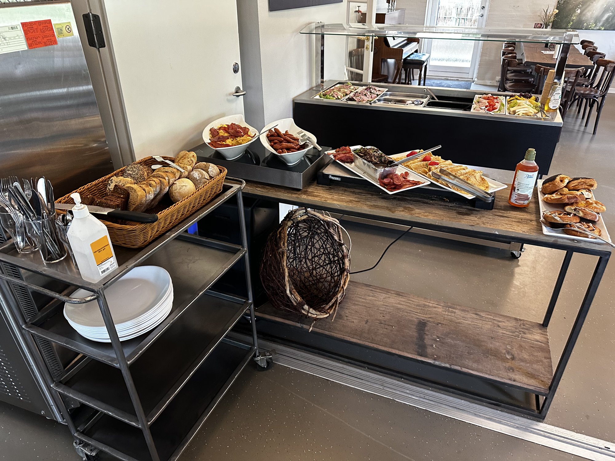 Brunchbuffet im Café mit Brot, Rührei, Würstchen und Aufschnitt